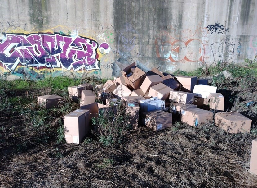 Scatole di mascherine lasciate sul greto dell'Arno