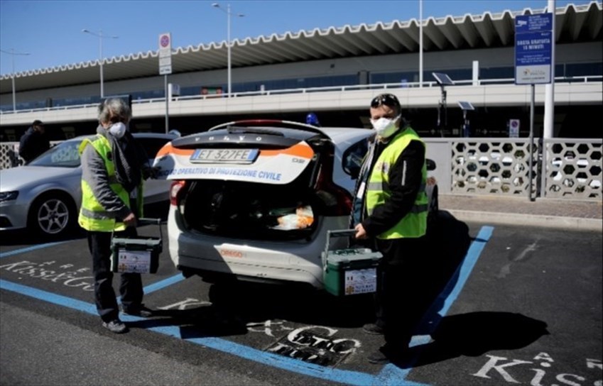 Massimo e Nadia caricano le borse termiche nel bagagliaio all'aeroporto di Fiumicino