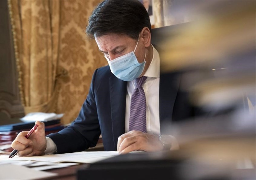 Giuseppe Conte che firma il dpcm