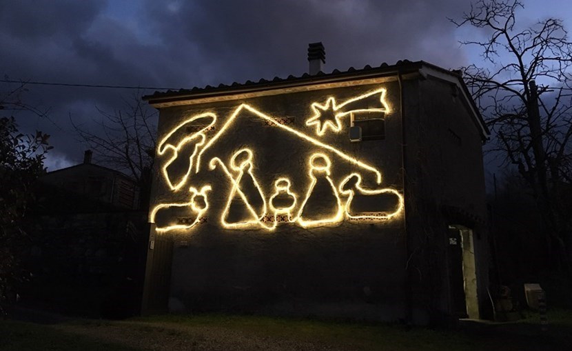 Un presepe luminoso sulla facciata di una capanna